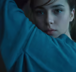 a woman with blue eyes is in a dark room