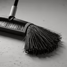 a broom cleaning a table top with a micro mop
