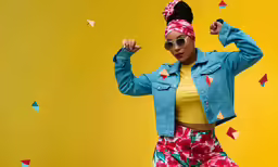 a woman standing in front of a yellow background with her arms behind her back