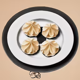 there are four dumplings on the white plate