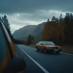 an old car on the road in front of some mountains