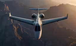 a white commercial plane flying over some mountains