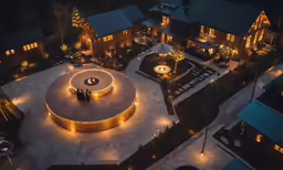 an aerial view of a building and its gardens at night