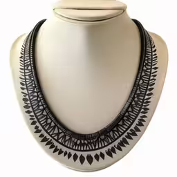 a black and white statement necklace on a display stand,a white ceramic display displaying a multi stranded necklace with black details
