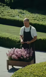 a man with an apron is pushing some sort of garden cart