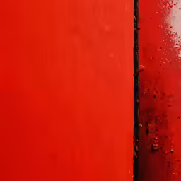the corner of a red wall with water droplets