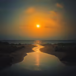 the sun is setting over the ocean and the ocean is calm