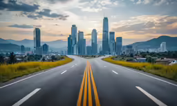 a highway with buildings in the background at sunset