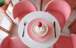 a pink chair around a white plate with food on top