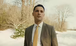a man in a suit wearing a yellow tie