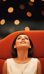 woman in red chair looking up and shining with lights on the wall