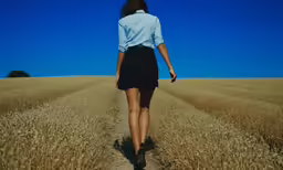 a girl walking alone through a field
