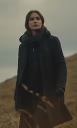a woman standing in the middle of a field