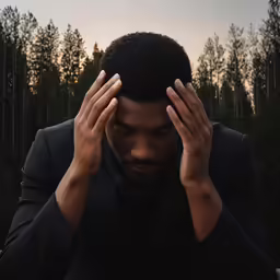 a man holds his head with one hands