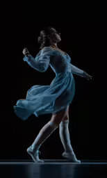 a woman wearing a dress and knee socks on stage