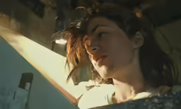 a young woman looking out a window while holding onto a door handle