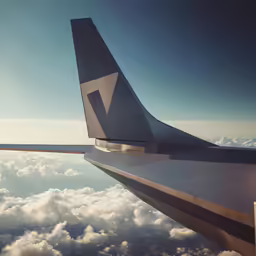 a jet airplane wing above the clouds at sunset