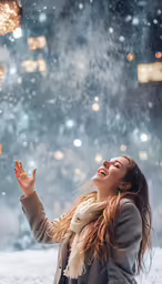 a woman sitting in the snow and laughing with lights on her feet
