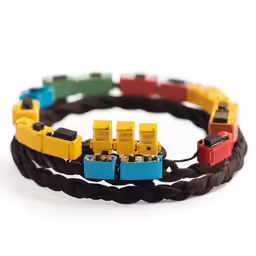 a couple of yellow and blue trains on a brown leather cord