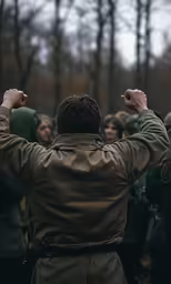 a man wearing a brown jacket is raising his fists
