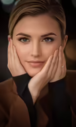 a woman in a brown suit with her hands on her face