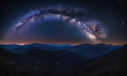 the milky shines in the night sky with mountains below