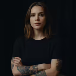 a woman with tattoos in a black shirt