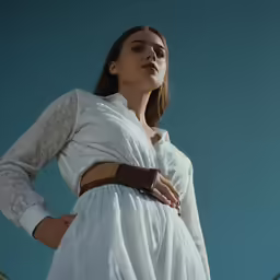 woman with arms crossed and looking up at sky