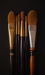 an array of different sized brushes resting on a dark surface