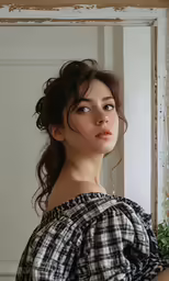 a woman with wavy hair stands in front of a mirror