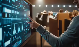 a man pointing at a blackboard with data on it