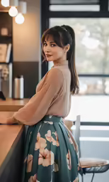 woman in a brown sweater and green floral skirt