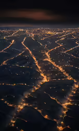 an airplane wing is flying over an overview of lights