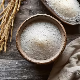 there is a bowl and two spoons full of rice on the table