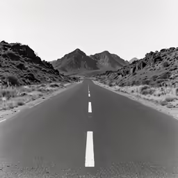 an empty road leads through some mountains