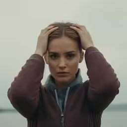 the woman has her hair covered and looking off into the distance