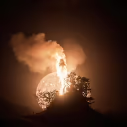 the smoke is rising in the dark and glowing