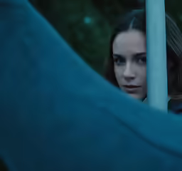 a young woman looking over the railing in a shadowy area