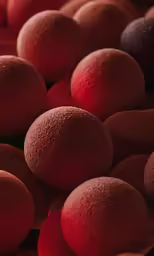 a bunch of round, shiny red fruits, on display