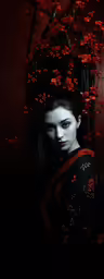 woman in geisha kimono next to japanese tree