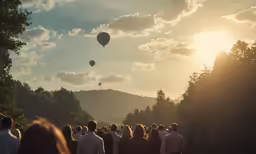 several people watching balloons in the sky