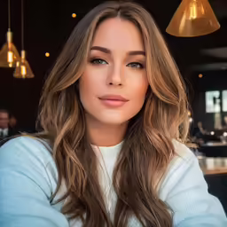 the woman with long hair is looking into the camera