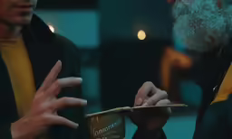 two men are doing something on a cup