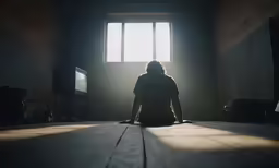 a person sitting on the floor and sunlight streaming through