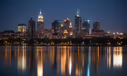 a nighttime view of a city and its surrounding lake