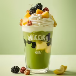 a cup filled with green fruit sitting next to sliced lemons and a blackberries