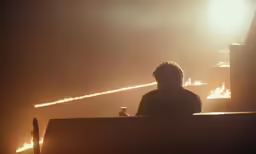 a man that is sitting in front of a lit object