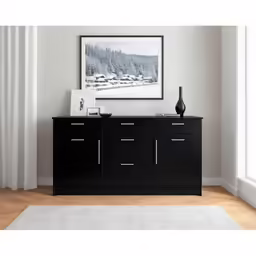 a small vase on a black cabinet in front of a photograph