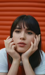 a woman is posing against a red wall