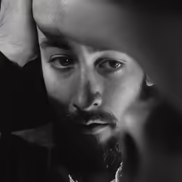 a man is holding his head with one hand